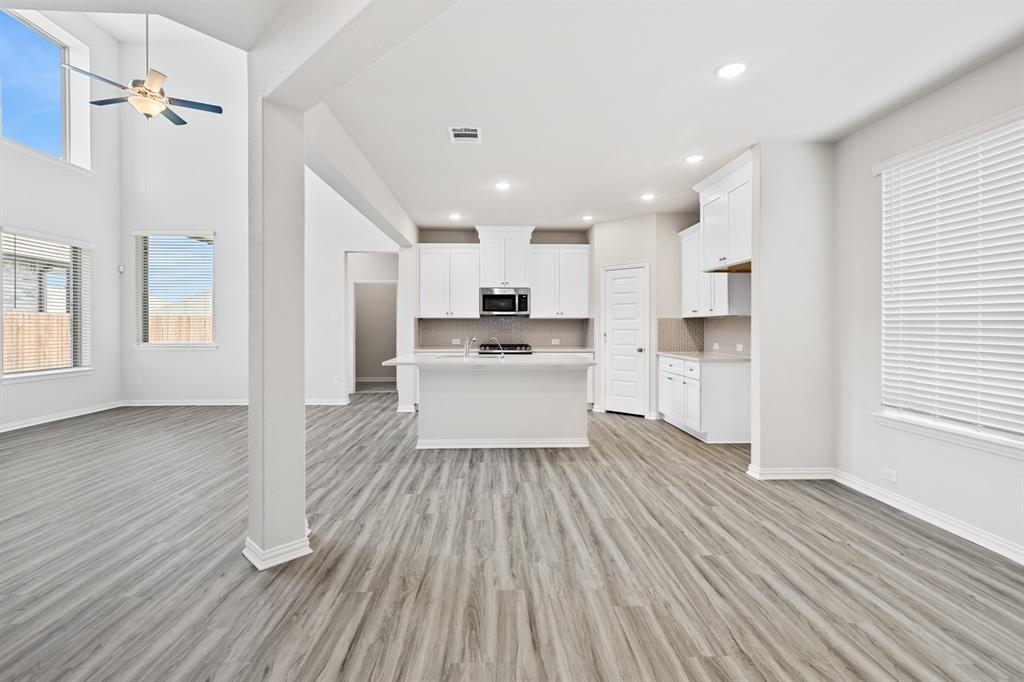 4149 Beale Street Heartland, TX 75114 - Photo 9 of 27 a kitchen with wooden floors and white appliances
