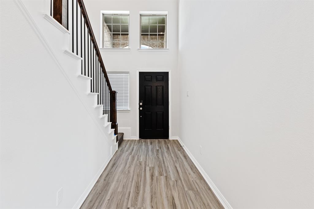4149 Beale Street Heartland, TX 75114 - Photo 10 of 27 a view of a hallway with wooden floor and staircase