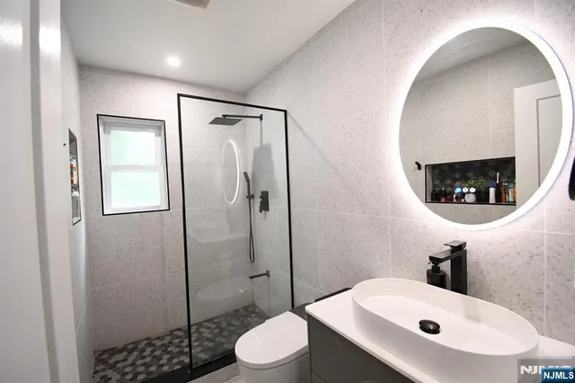 a bathroom with a sink a toilet and shower