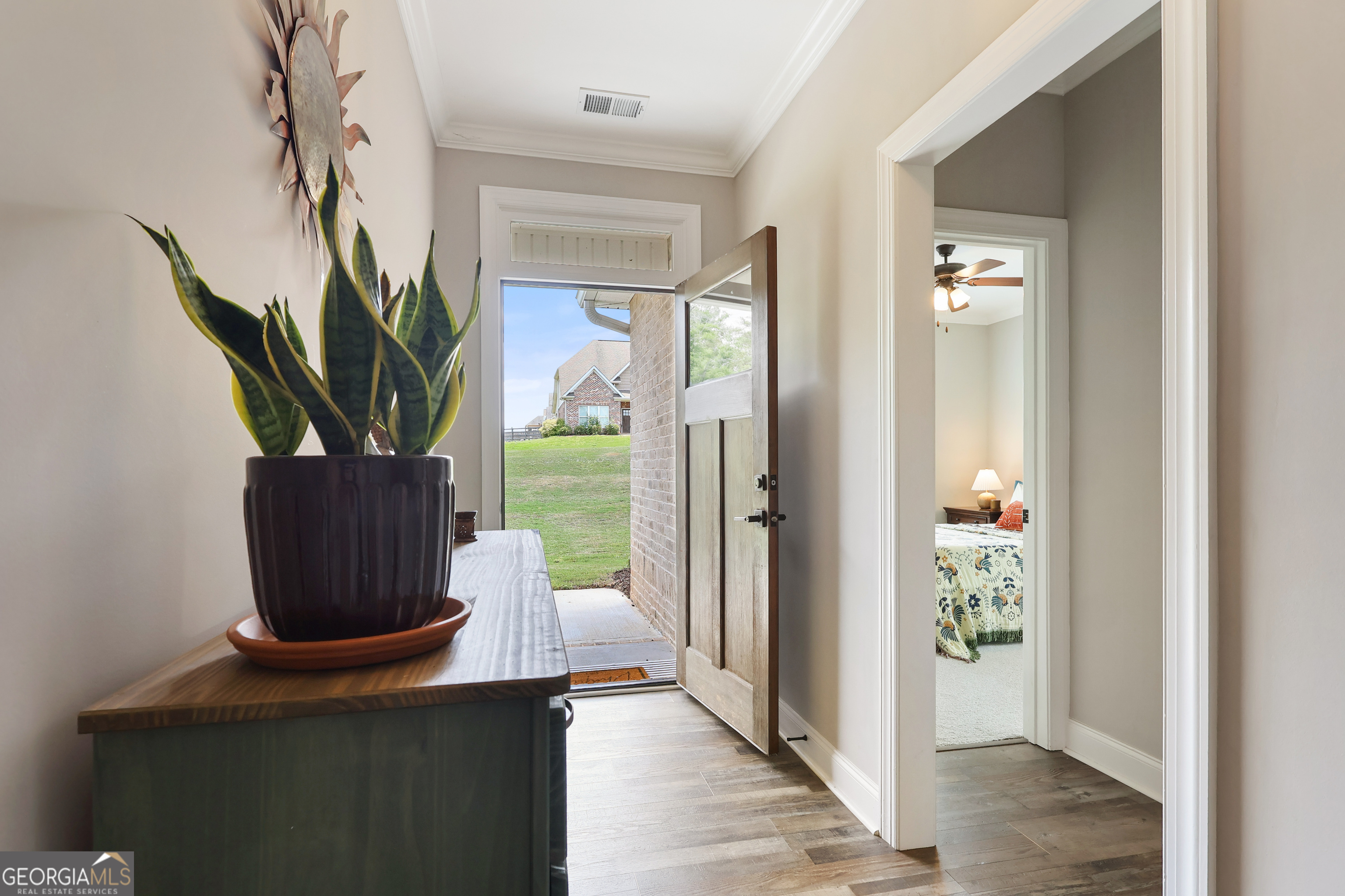 89 Claire Road Forsyth, GA 31029 - Photo 4 of 40 a view of a hallway with wooden floor and a potted plant