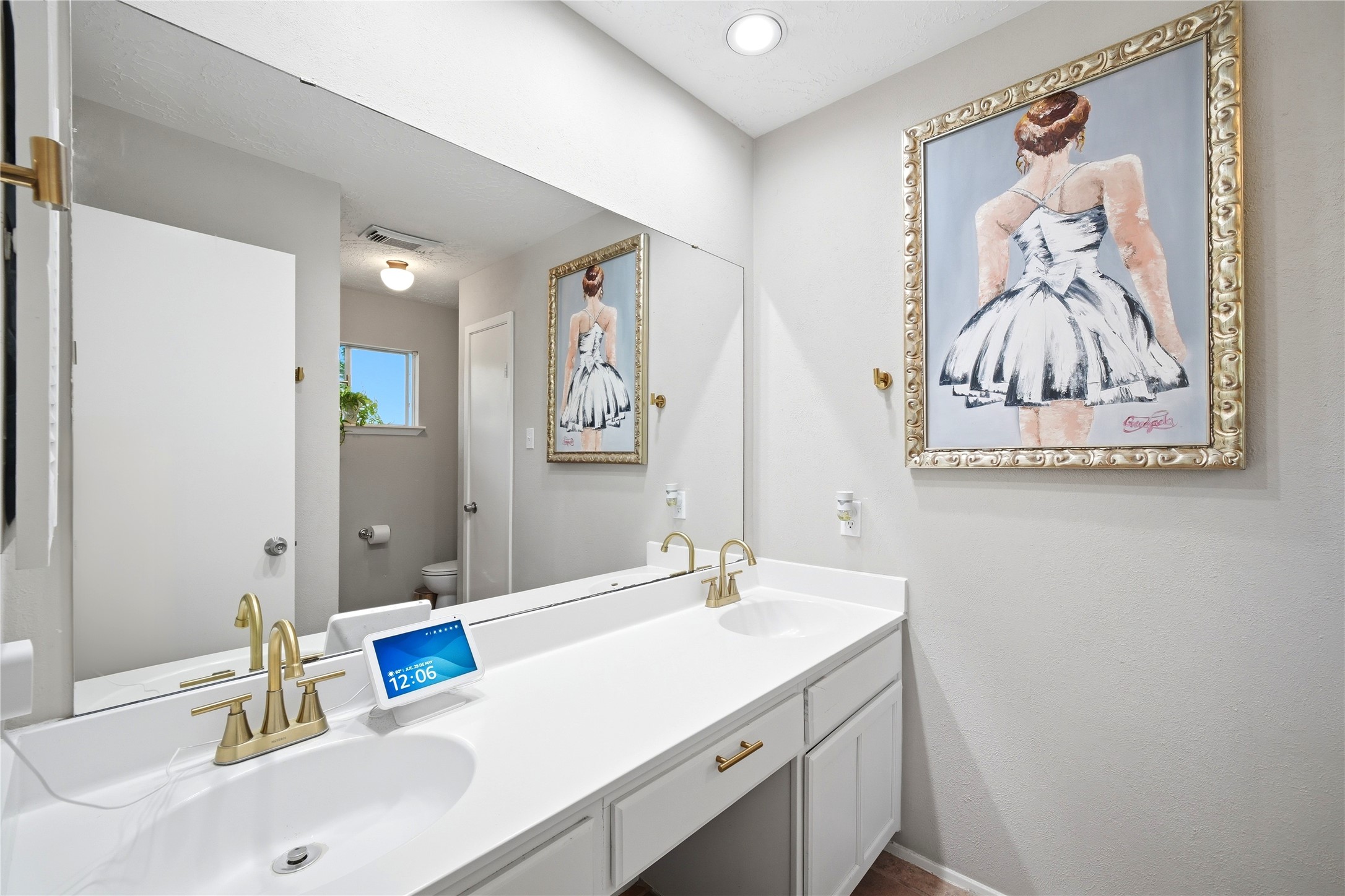 4718 Temple Bell Drive Spring, TX 77388 - Photo 34 of 50 This bathroom features a double vanity with sleek, modern fixtures and ample counter space. The neutral color palette is complemented by a large, decorative framed artwork. A small window allows natural light to brighten the space, adding to its inviting atmosphere.