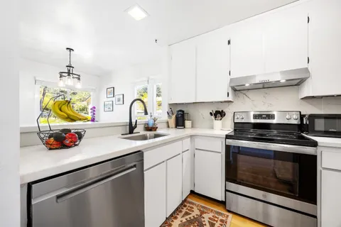 a kitchen with a sink a stove and cabinets