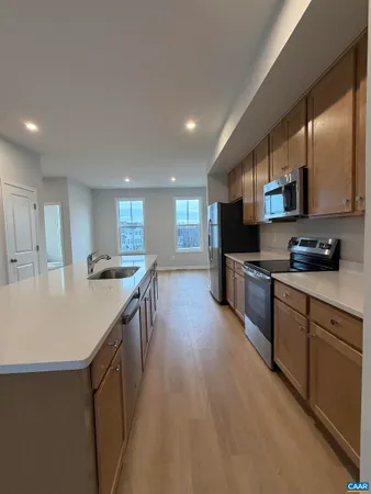 a kitchen with stainless steel appliances granite countertop a sink a stove and a refrigerator