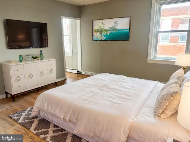a bedroom with a large bed and a flat screen tv