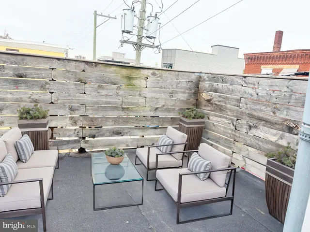 a roof deck with couch and iron fence