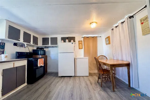 a kitchen with cabinets and wooden floors