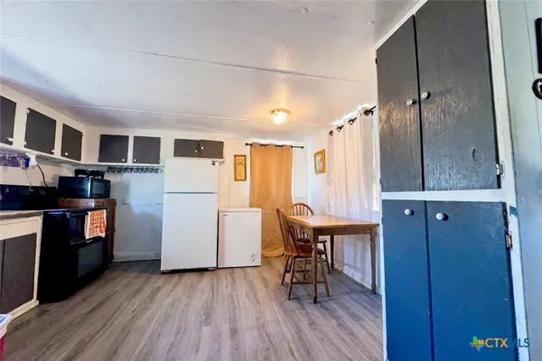 a kitchen with stainless steel appliances granite countertop wooden floors a stove and a refrigerator