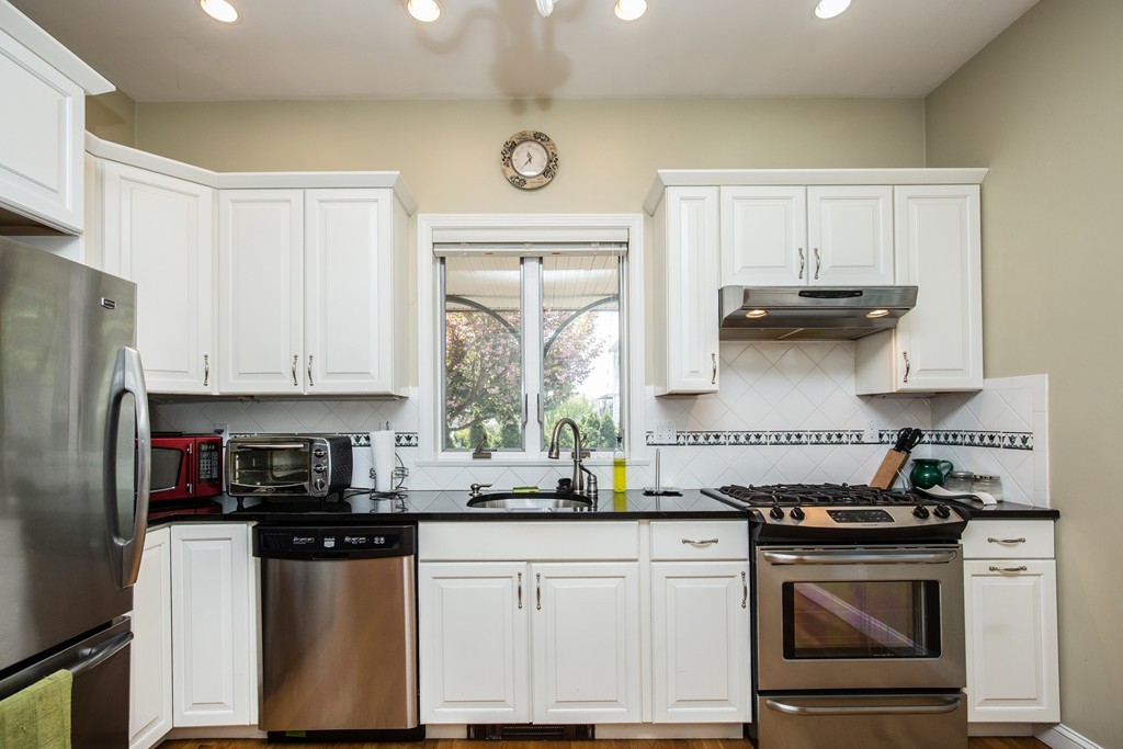 35 Winthrop Street Everett, MA 02149 - Photo 25 of 30 a kitchen with stainless steel appliances granite countertop a refrigerator a stove a sink and white cabinets