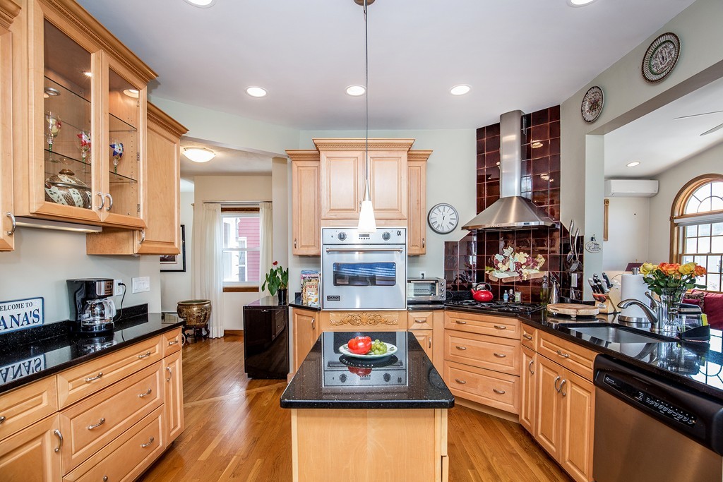 35 Winthrop Street Everett, MA 02149 - Photo 8 of 30 a kitchen with stainless steel appliances granite countertop a stove a sink dishwasher and cabinets with wooden floor