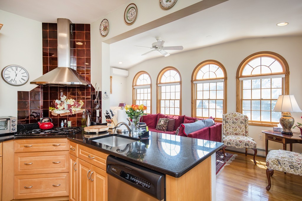 35 Winthrop Street Everett, MA 02149 - Photo 9 of 30 a kitchen with stainless steel appliances granite countertop a stove a kitchen island a dining table and chairs with wooden floor