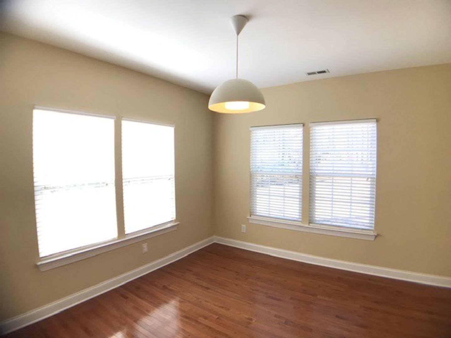 1120 Riggins Mill Road Cary, NC 27519 - Photo 17 of 34 a view of an empty room with wooden floor and a window