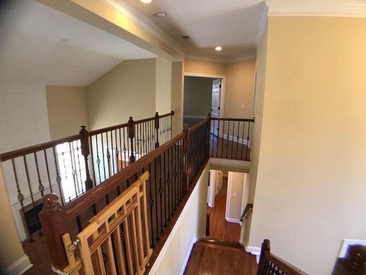1120 Riggins Mill Road Cary, NC 27519 - Photo 19 of 34 a view of a hallway with wooden floor and staircase