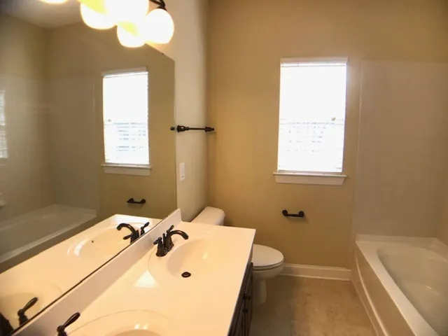 a bathroom with a tub sink and mirror