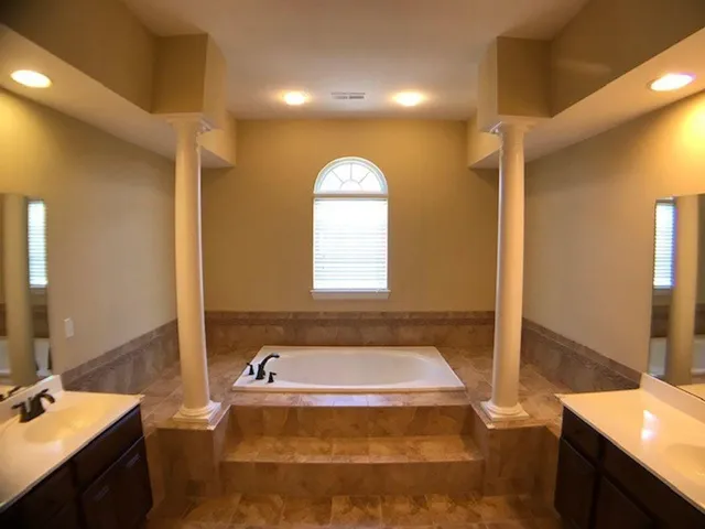 a bathroom with a tub sink and mirror