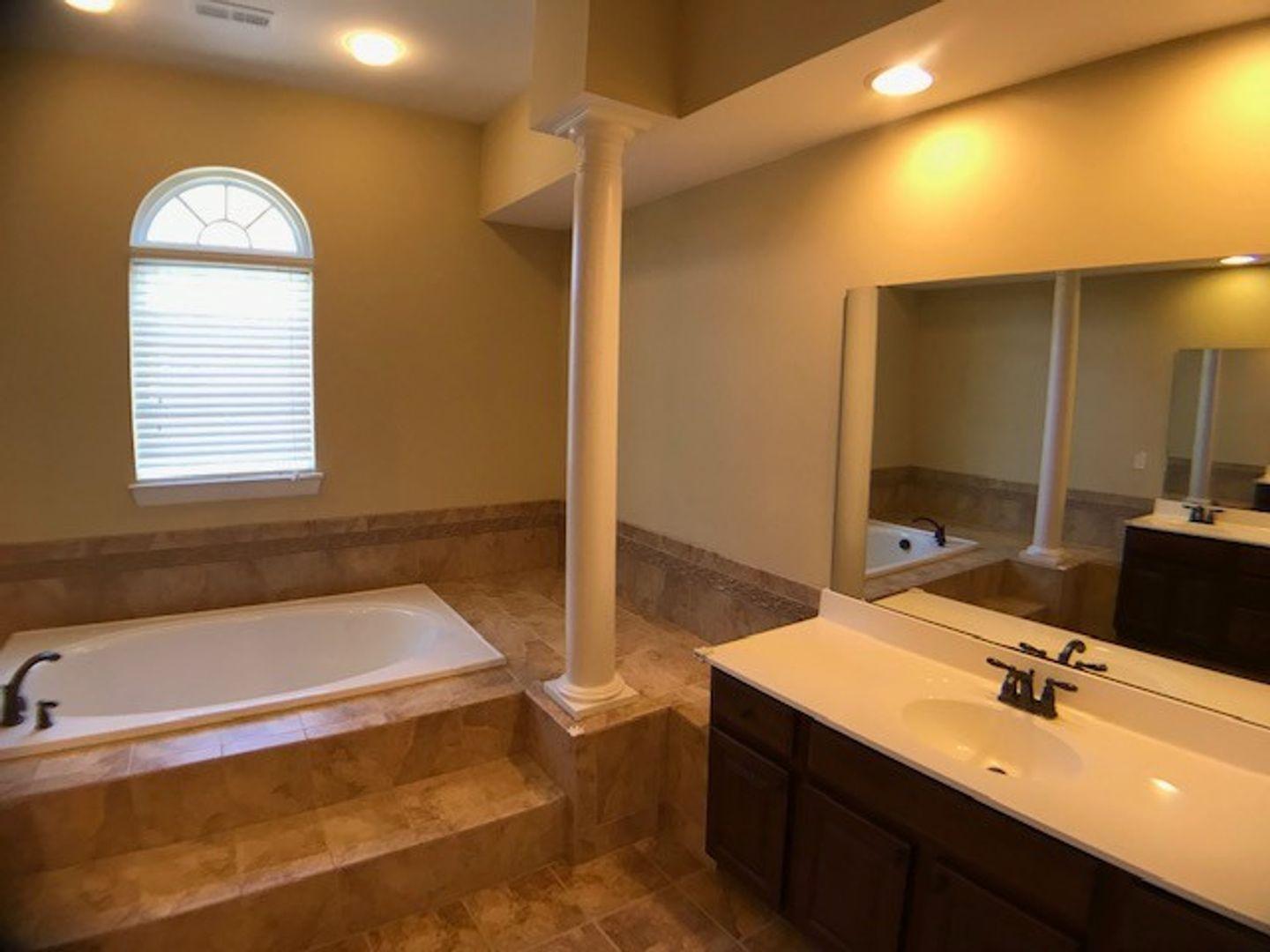 1120 Riggins Mill Road Cary, NC 27519 - Photo 30 of 34 a bathroom with a tub sink and mirror