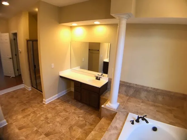 a bathroom with a tub sink and mirror