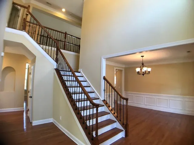 a view of staircase with wooden floor and white walls