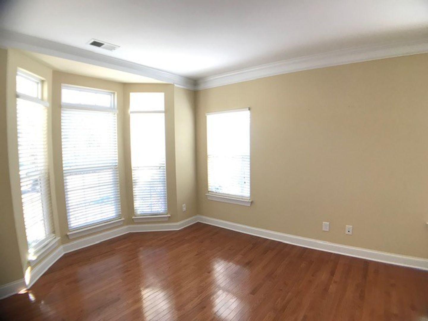 1120 Riggins Mill Road Cary, NC 27519 - Photo 7 of 34 an empty room with wooden floor and windows