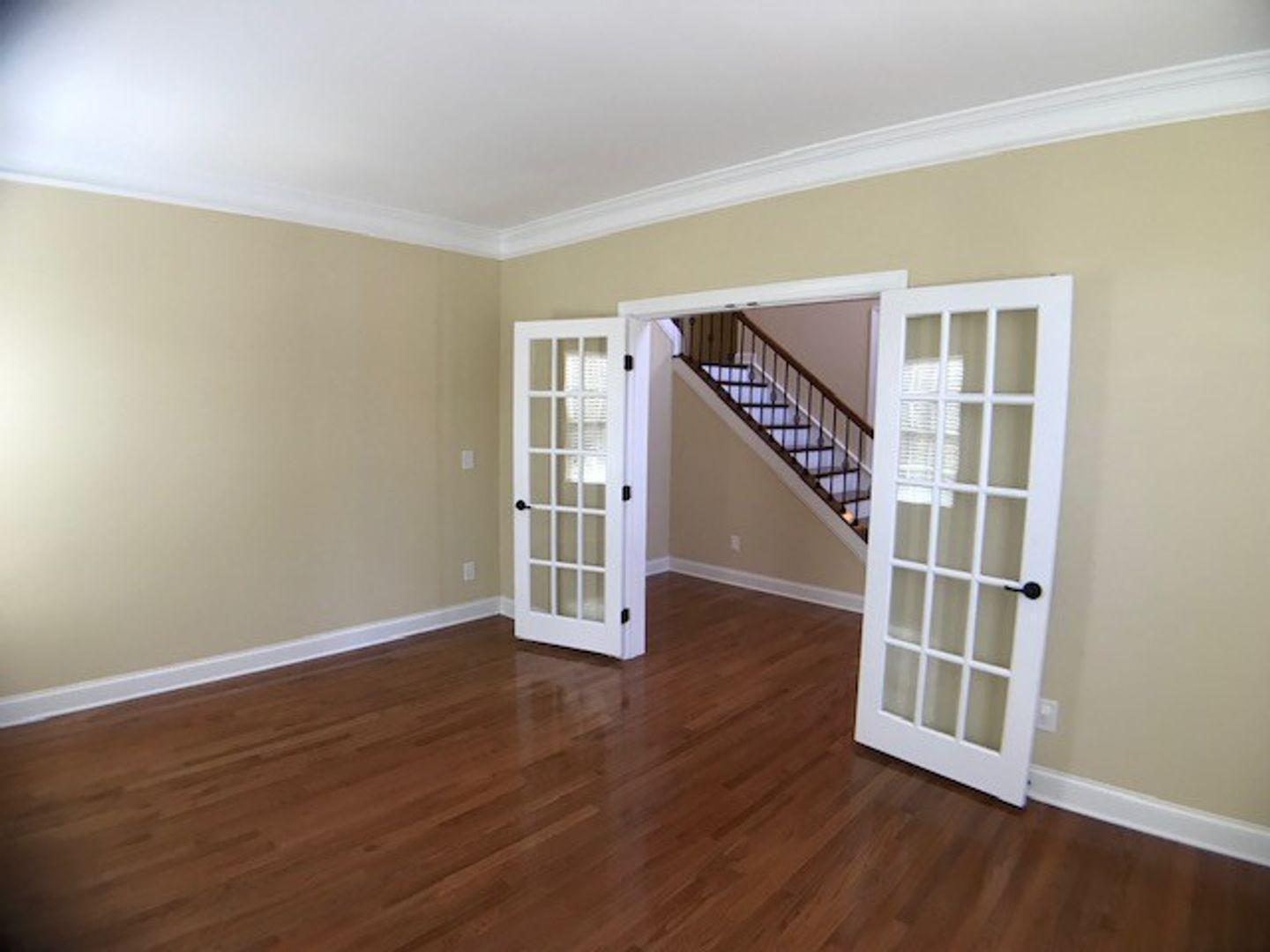1120 Riggins Mill Road Cary, NC 27519 - Photo 8 of 34 a view of an empty room with wooden floor and stairs
