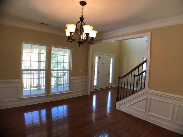 a view of a livingroom with wooden floor a chandelier