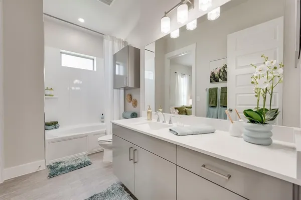 a bathroom with a sink a potted plant and a large mirror