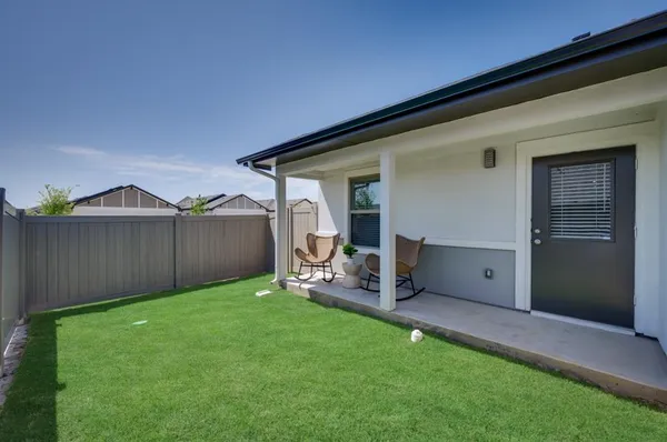 a view of a backyard with table and chairs and a barbeque