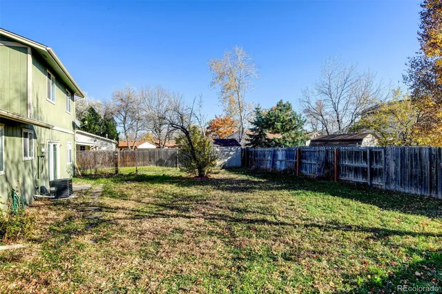 a view of a yard with wooden fence