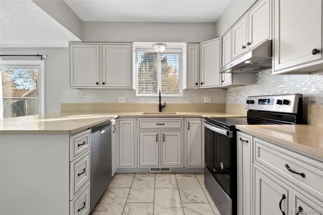 a kitchen with granite countertop a sink stainless steel appliances and cabinets