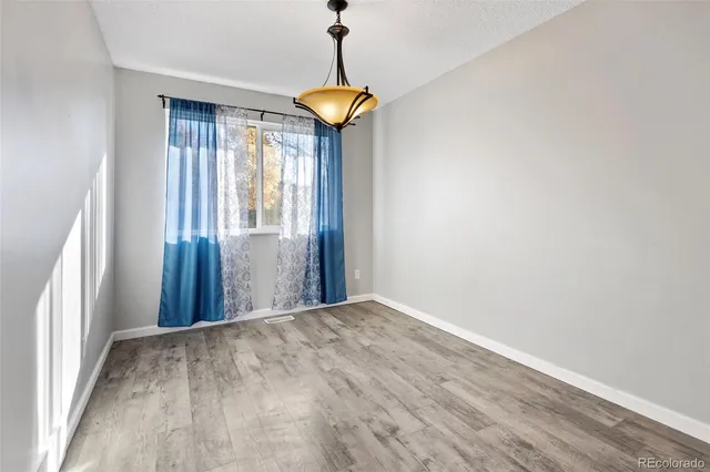 a view of a room with a chandelier and wooden floor
