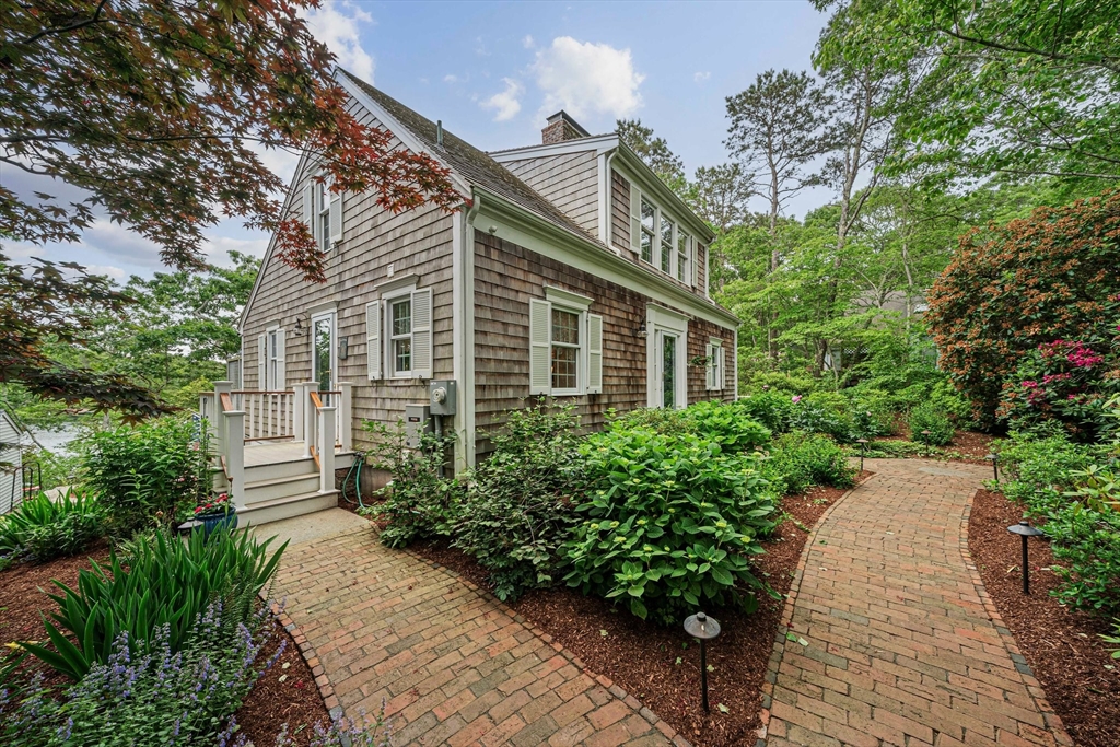 74 Fells Pond Road Mashpee, MA 02649 - Photo 2 of 36 a front view of a house with a yard and potted plants