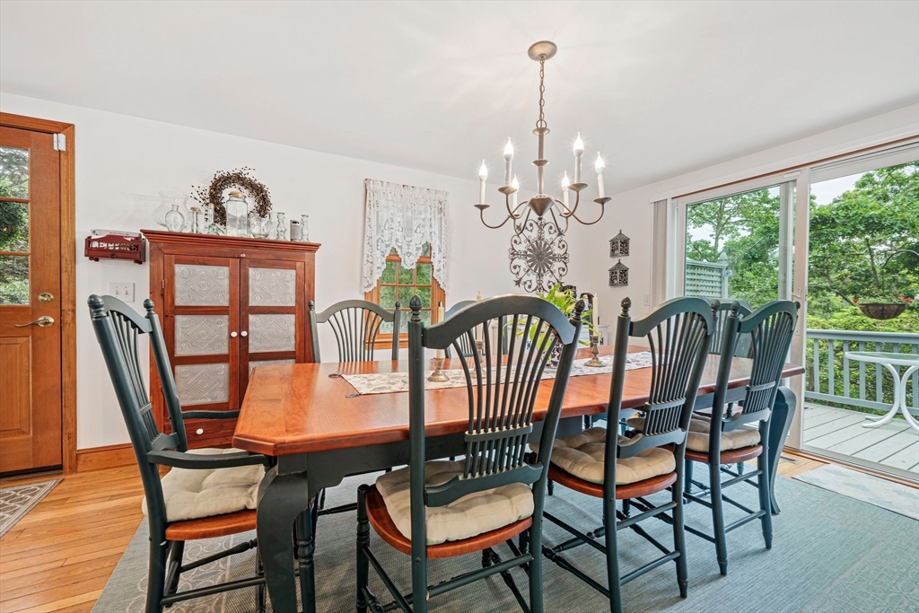 74 Fells Pond Road Mashpee, MA 02649 - Photo 6 of 36 a dining room with furniture a rug a potted plant and a chandelier