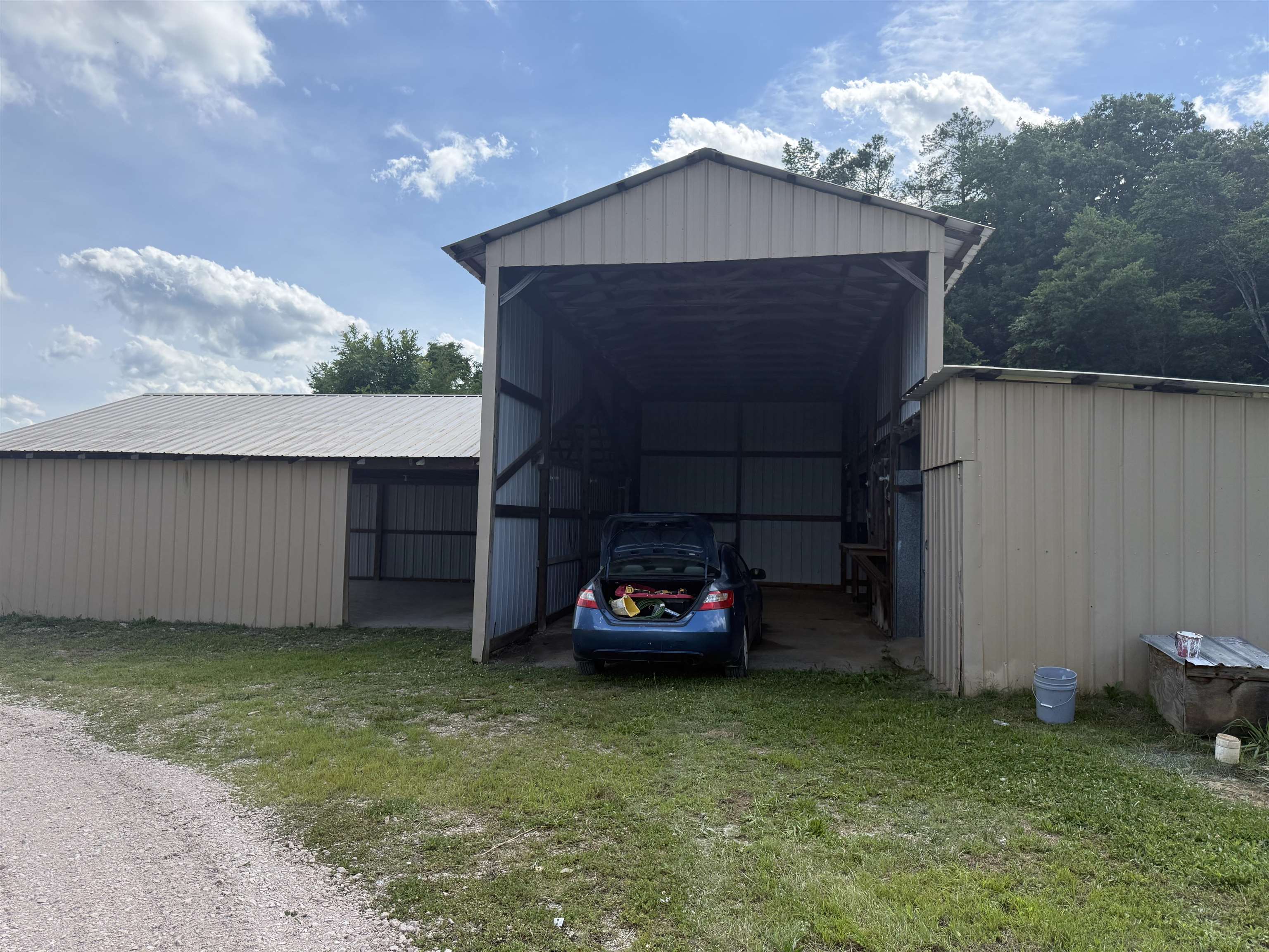 170 Leapwood Road Enville, TN 38332 - Photo 31 of 33 Expansive metal outbuilding with a high-pitched roof and an open-sided storage area