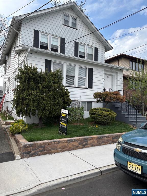 a front view of a house with a garden and plants