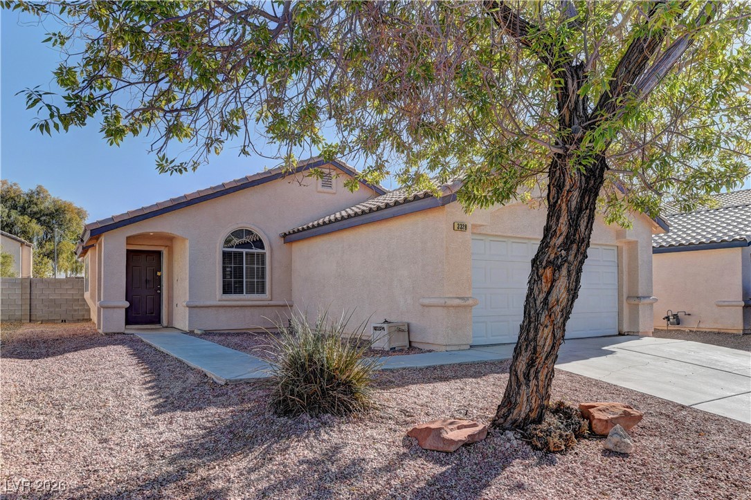 Mediterranean / spanish-style home featuring a garage, driveway, a tile roof, and stucco siding