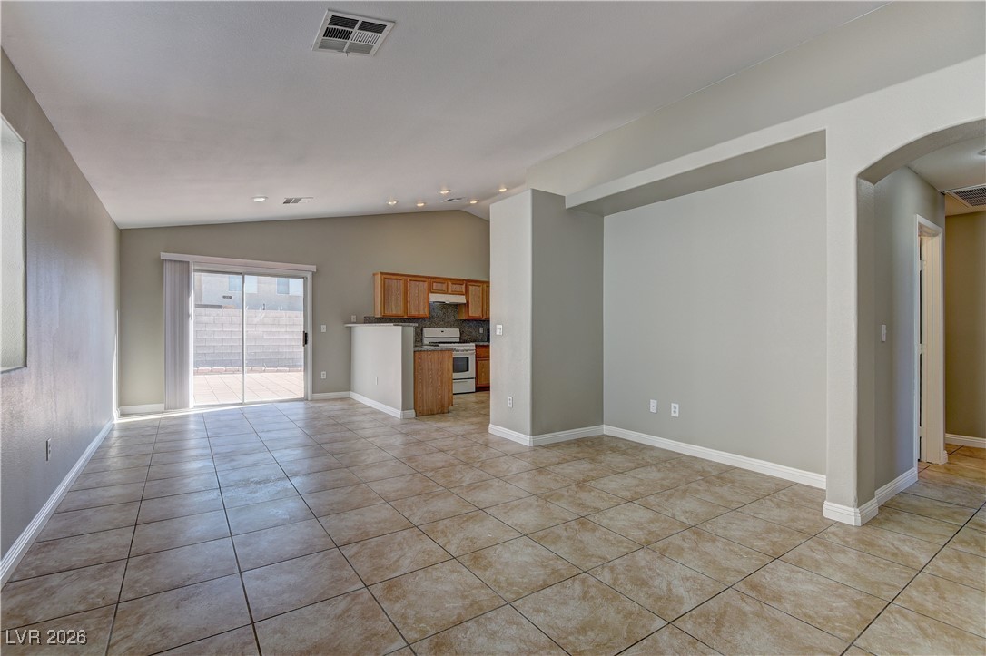 3328 Strawberry Roan Road North Las Vegas, NV 89032 - Photo 2 of 11 Unfurnished living room with lofted ceiling, arched walkways, and light tile patterned flooring