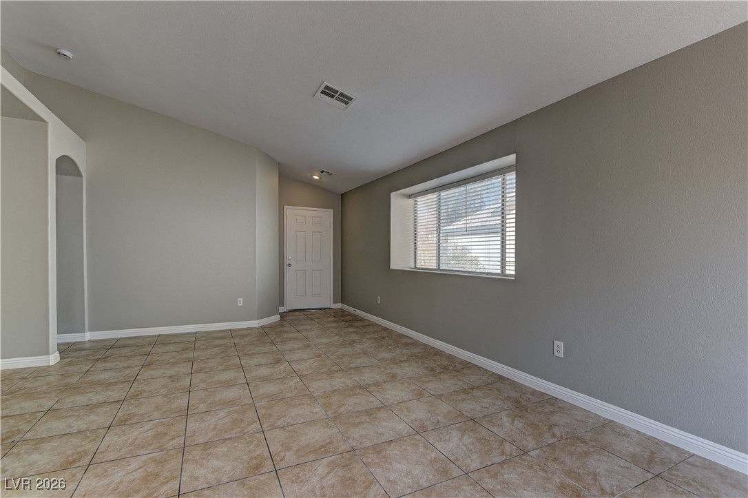 3328 Strawberry Roan Road North Las Vegas, NV 89032 - Photo 3 of 11 Spare room featuring vaulted ceiling, arched walkways, and light tile patterned flooring