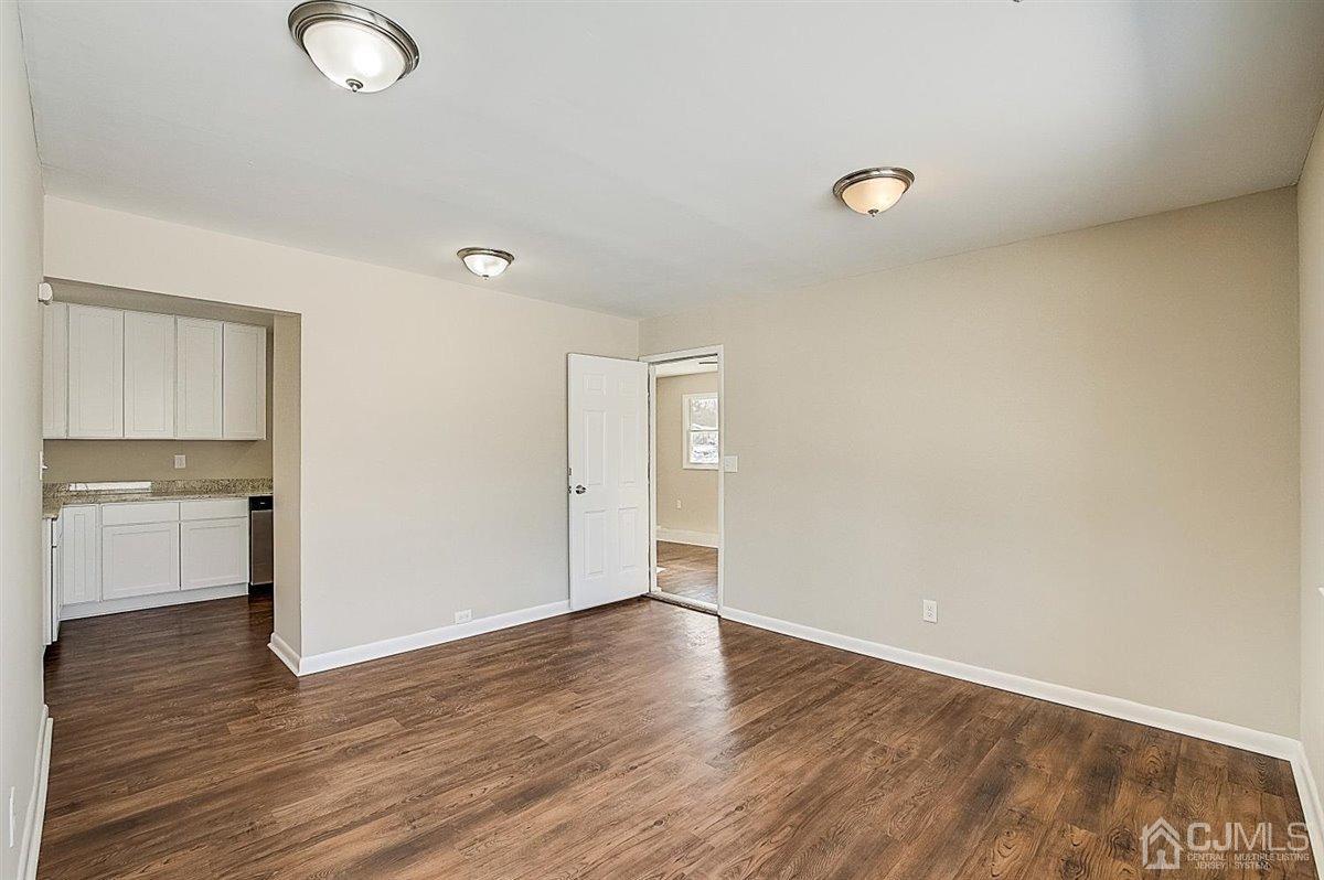 17 Cambridge Road Kendall Park, NJ 08824 - Photo 16 of 28 a view of an empty room with wooden floor and a window