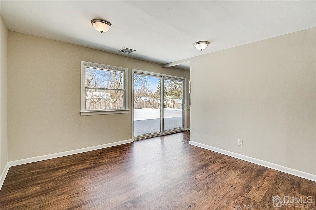 17 Cambridge Road Kendall Park, NJ 08824 - Photo 17 of 28 an empty room with wooden floor and windows