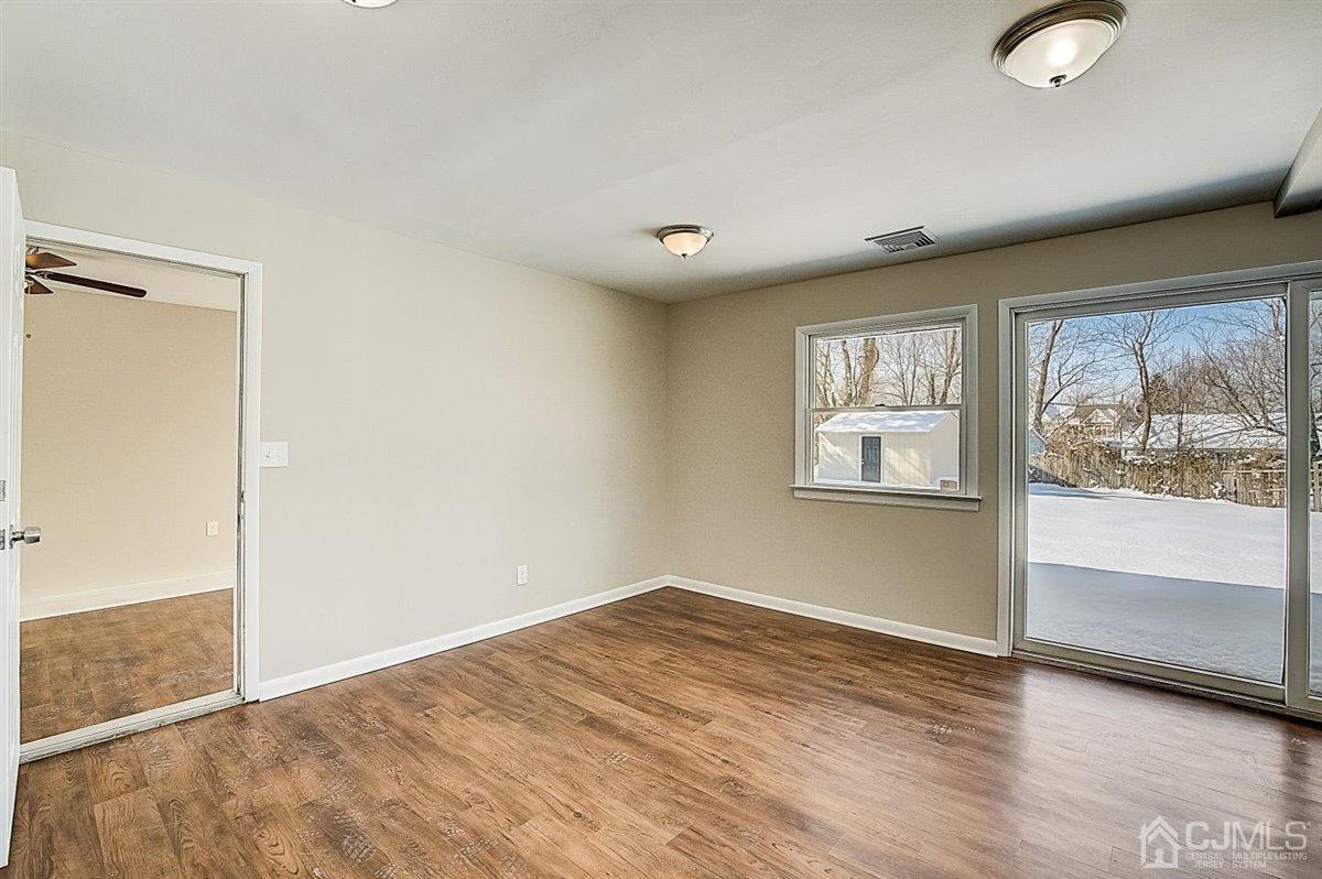 17 Cambridge Road Kendall Park, NJ 08824 - Photo 18 of 28 an empty room with wooden floor and windows