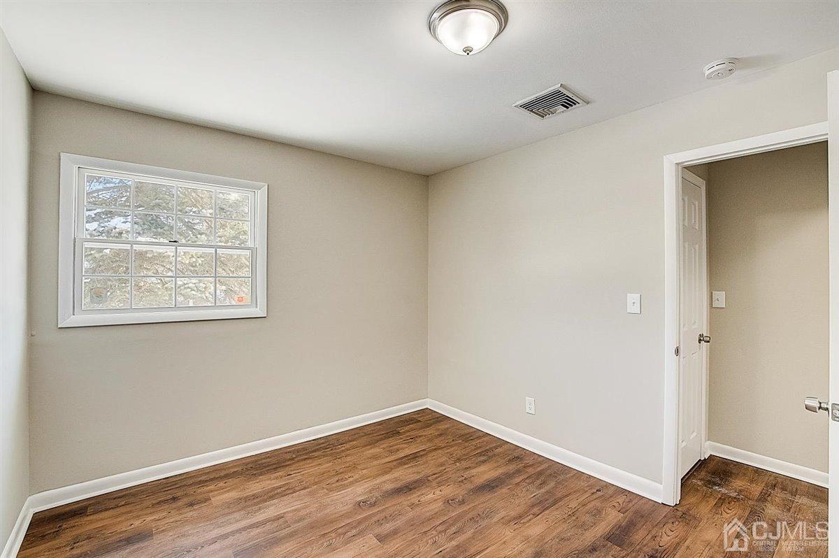17 Cambridge Road Kendall Park, NJ 08824 - Photo 22 of 28 an empty room with wooden floor and windows