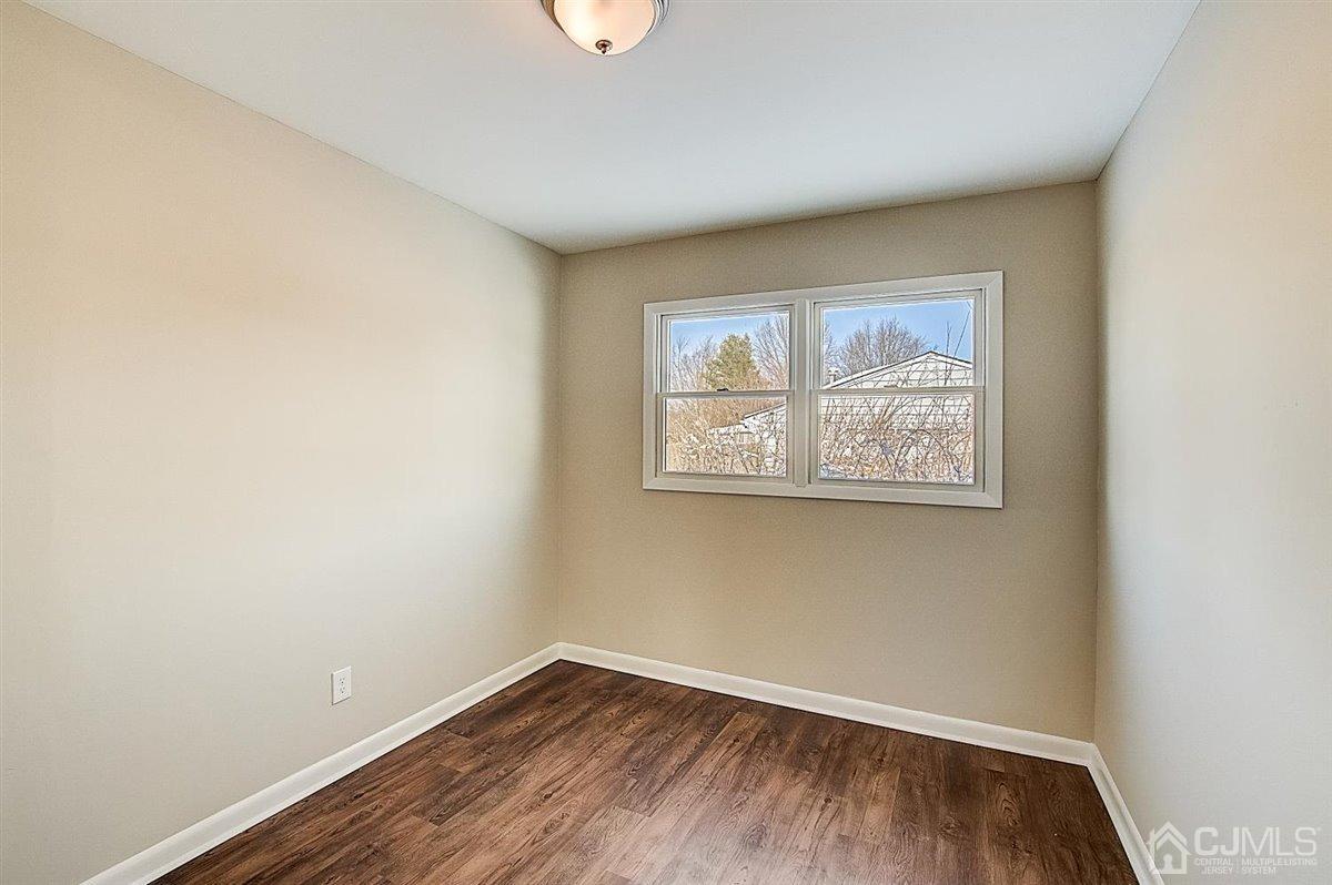 17 Cambridge Road Kendall Park, NJ 08824 - Photo 23 of 28 an empty room with wooden floor and window