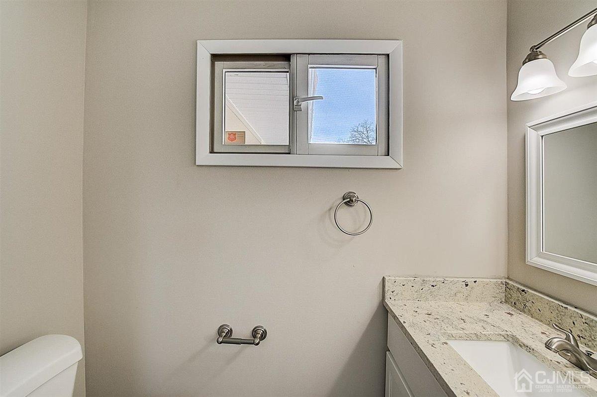 17 Cambridge Road Kendall Park, NJ 08824 - Photo 26 of 28 a bathroom with a granite countertop sink vanity mirror and toilet