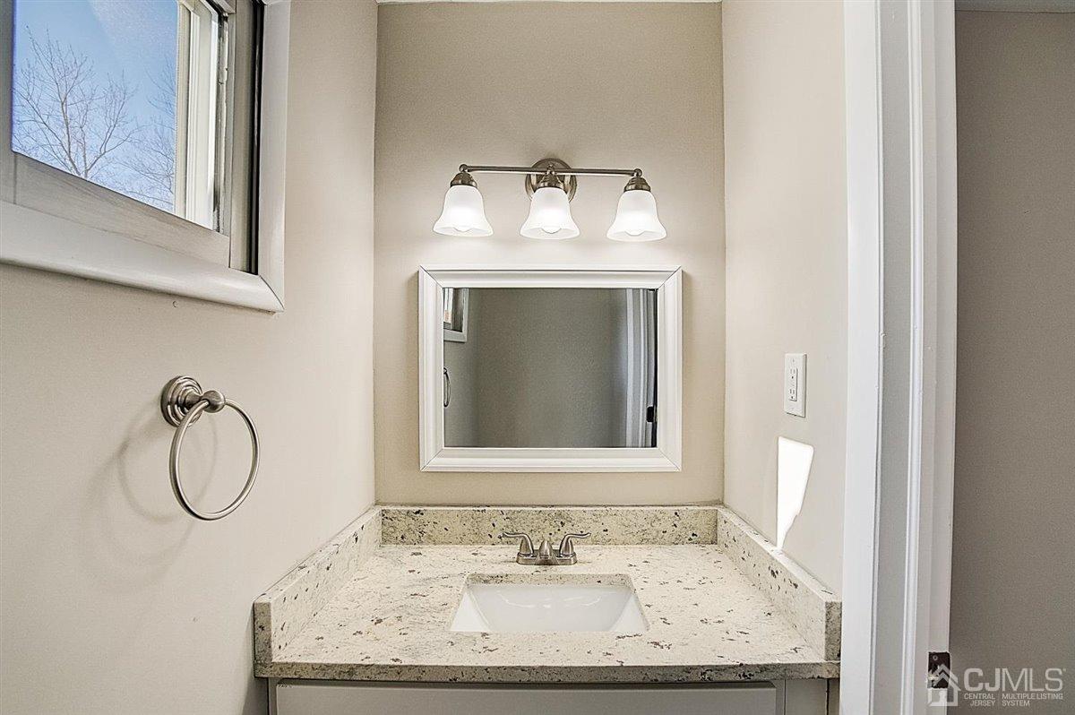 17 Cambridge Road Kendall Park, NJ 08824 - Photo 28 of 28 a bathroom with a granite countertop sink and a mirror