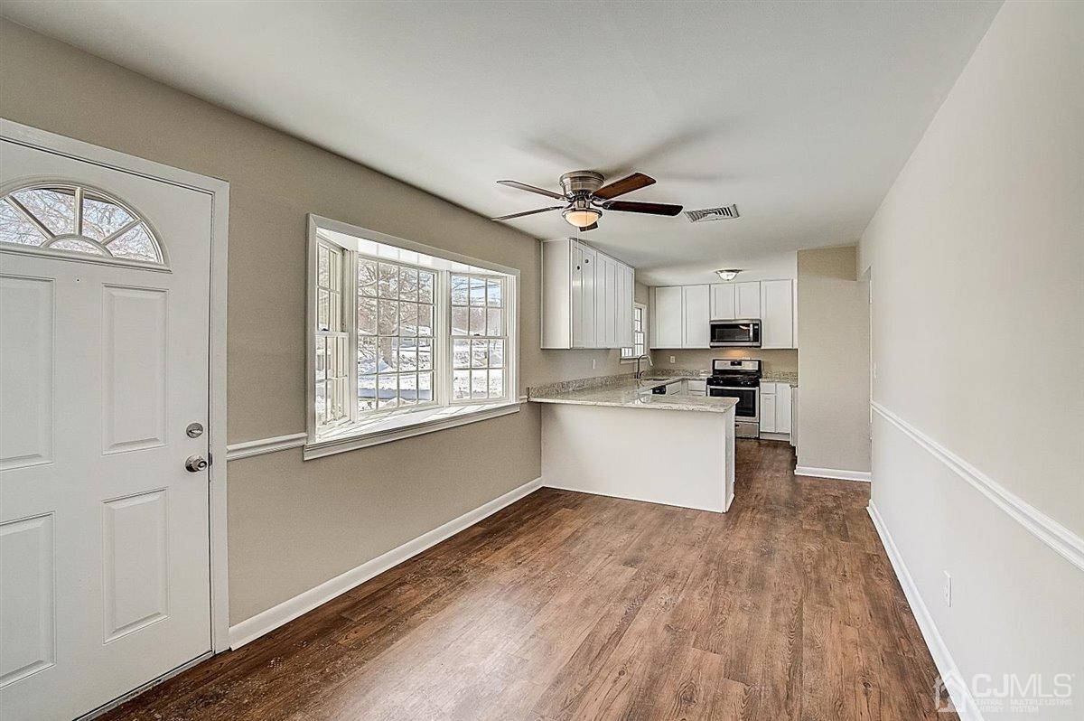 17 Cambridge Road Kendall Park, NJ 08824 - Photo 5 of 28 a kitchen with stainless steel appliances white cabinets and wooden floors