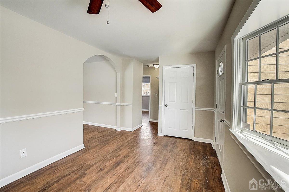 17 Cambridge Road Kendall Park, NJ 08824 - Photo 7 of 28 a view of an empty room with wooden floor and a window