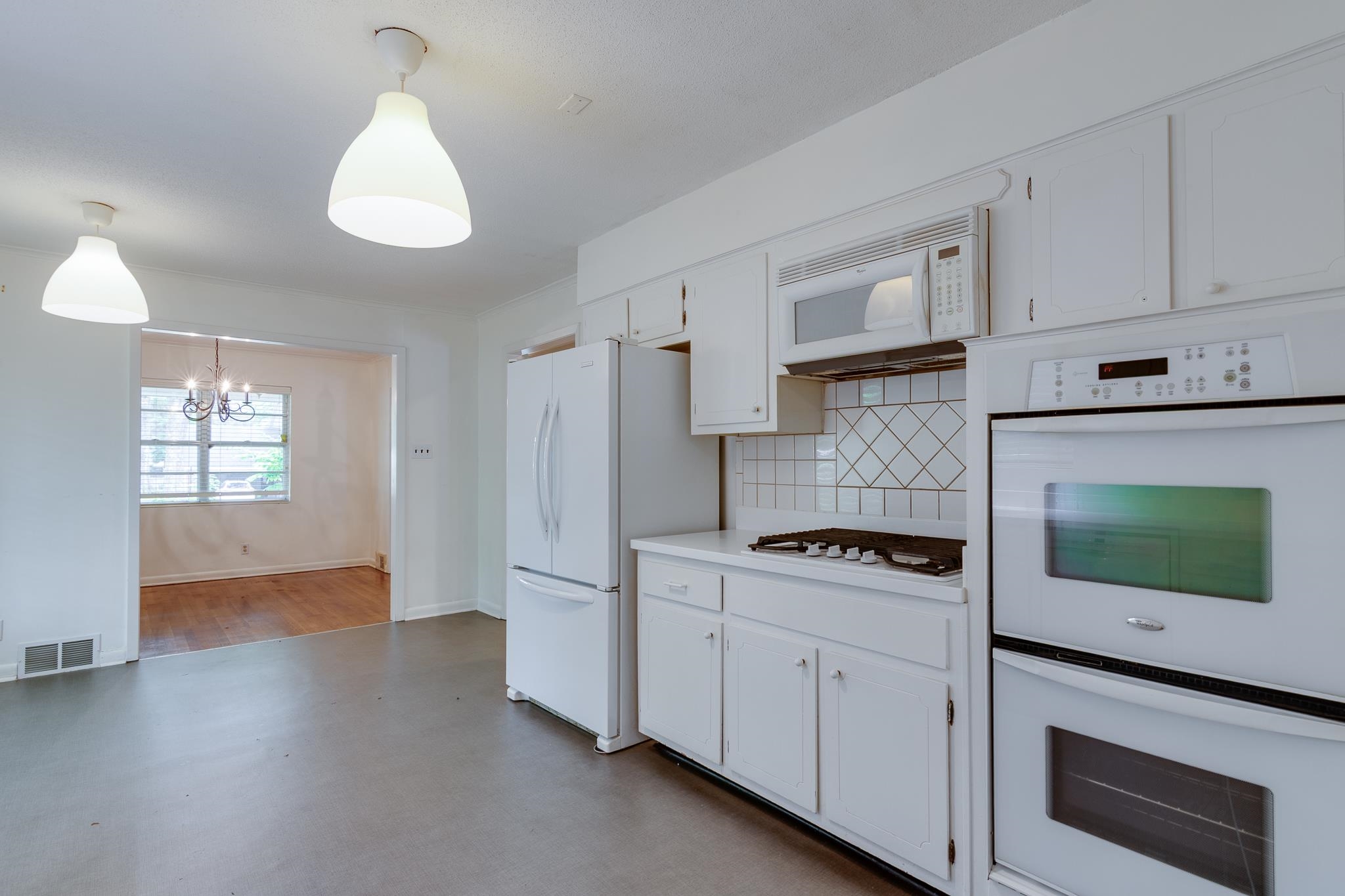 2021 Sunset Road Germantown, TN 38138 - Photo 11 of 26 Kitchen with a notable chandelier, white appliances, white cabinetry, tasteful backsplash, and visible vents
