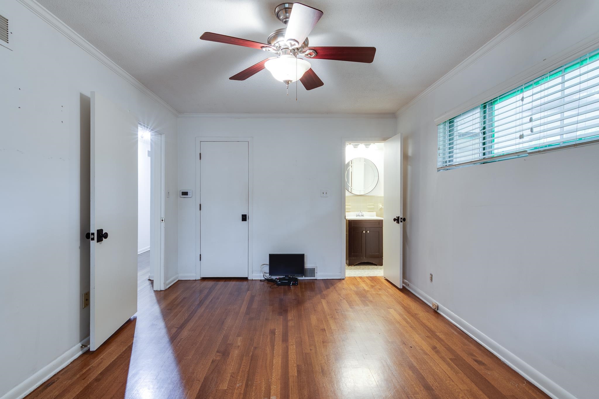 2021 Sunset Road Germantown, TN 38138 - Photo 19 of 26 Empty room with crown molding, visible vents, wood finished floors, baseboards, and a ceiling fan