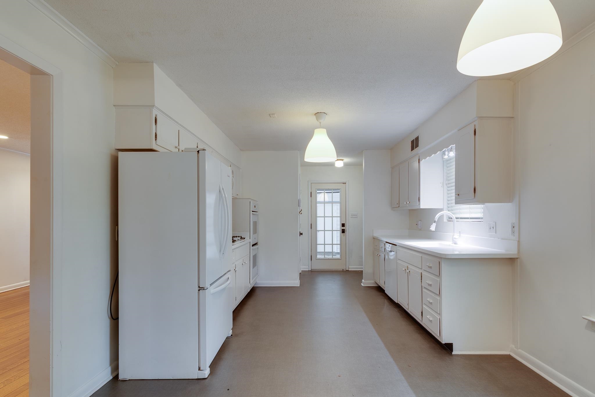 2021 Sunset Road Germantown, TN 38138 - Photo 5 of 26 Kitchen featuring freestanding refrigerator, white cabinetry, baseboards, and light countertops