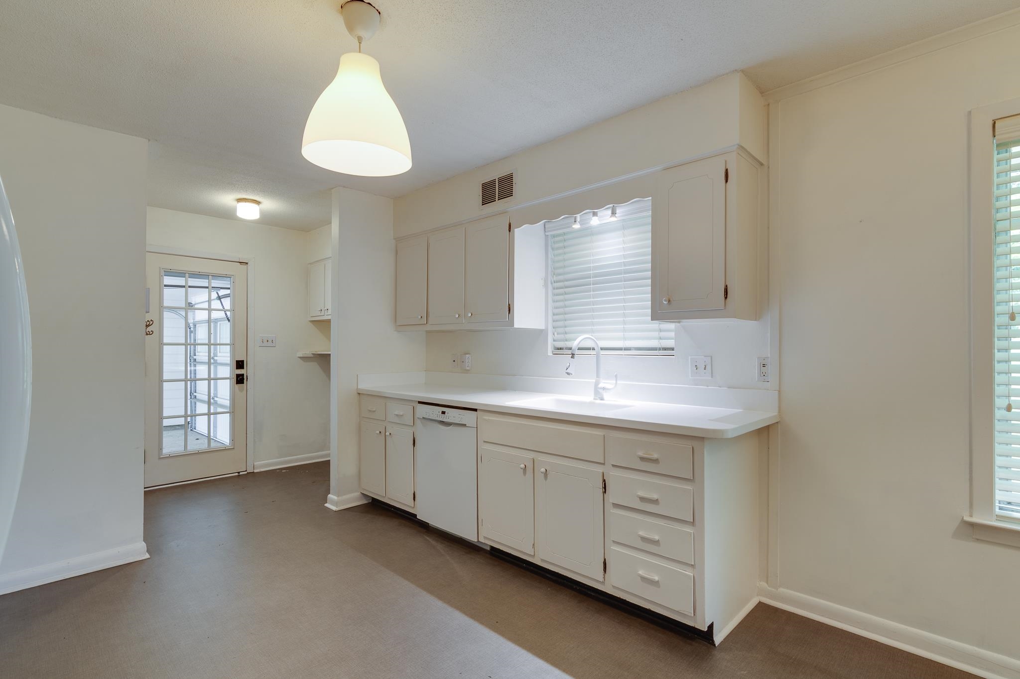 2021 Sunset Road Germantown, TN 38138 - Photo 7 of 26 Kitchen featuring white dishwasher, a sink, white cabinetry, baseboards, and visible vents