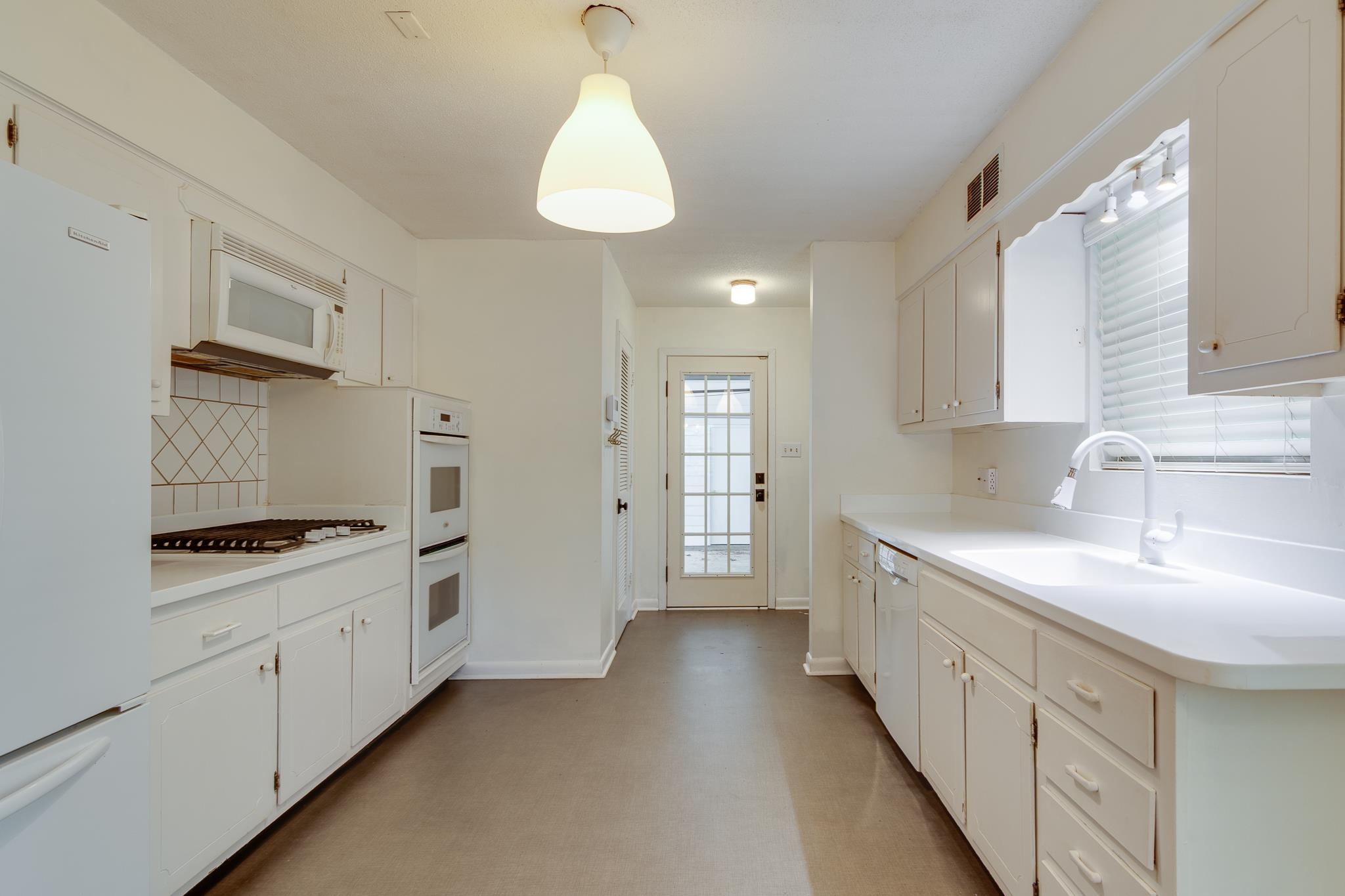 2021 Sunset Road Germantown, TN 38138 - Photo 8 of 26 Kitchen featuring a sink, white appliances, light countertops, decorative backsplash, and visible vents